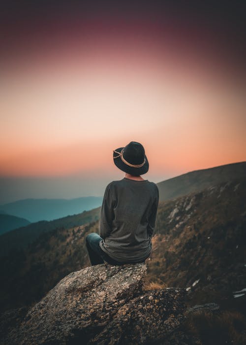 Person in Gray Top Sitting on Rock