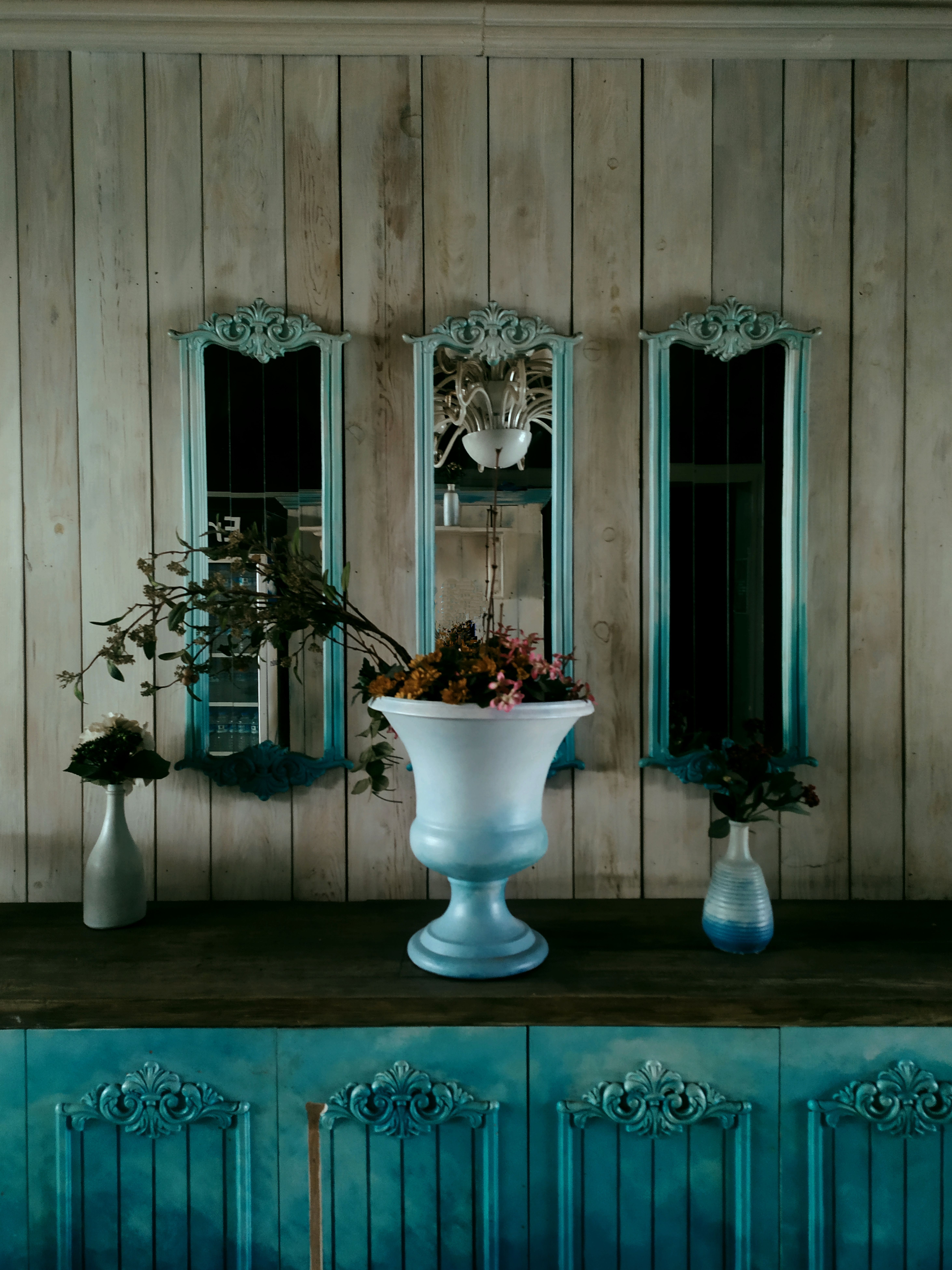 A blue vase with flowers on top of a wooden table · Free Stock Photo