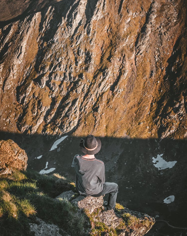 Man Sitting On Cliff