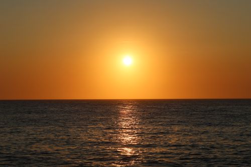 Free Serene ocean sunset at Nantucket with a vivid orange sky and glistening water. Stock Photo