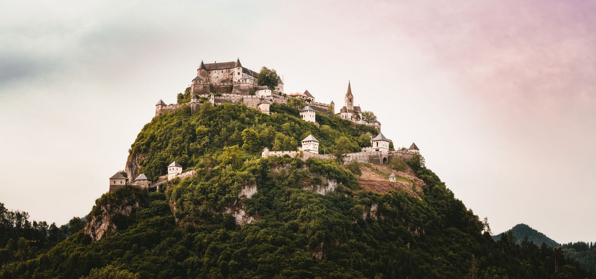 A Beautiful Castle Built On Top Of A Mountain Surrounded By Trees