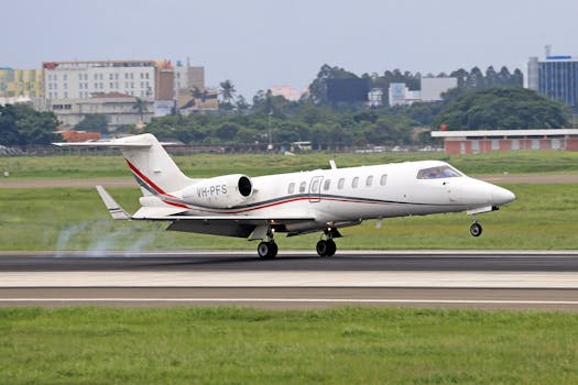 A sleek white private jet smoothly landing at a bustling airport, highlighting aviation technology.