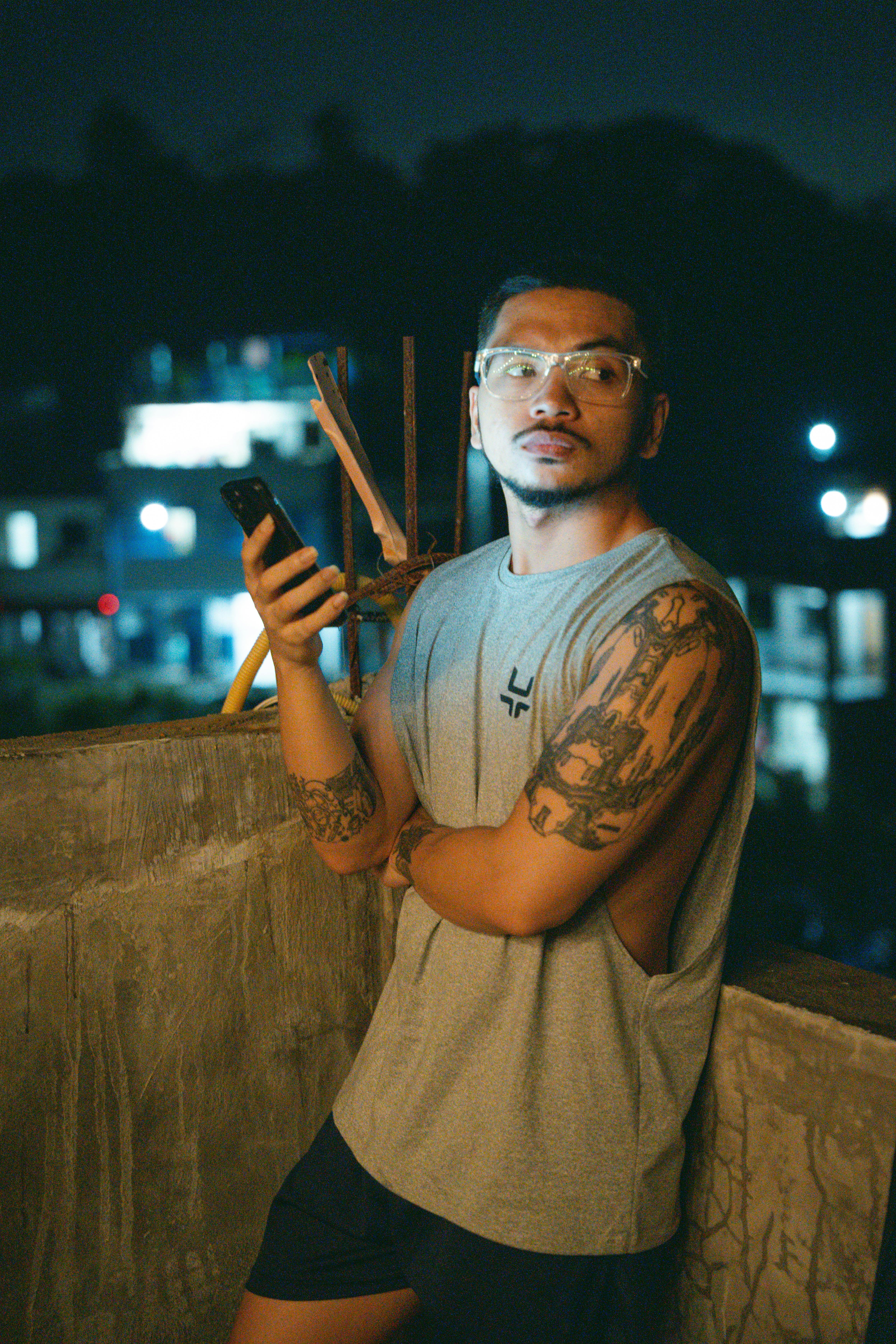 a man with tattoos holding a cell phone