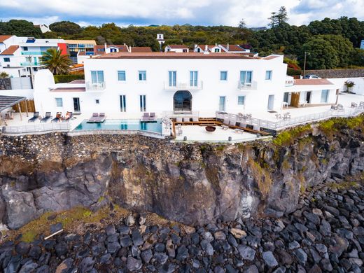 White cliff-top lodge with a pool deck over the rocks. Photo: Humphrey Muleba on Pexels