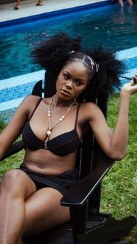 Stylish woman in swimwear lounging by the pool enjoying a summer day.