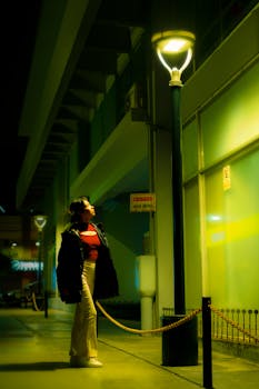 A person gazing at lamppost lights on a street in Miraflores, Lima at night.
