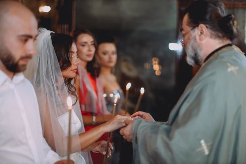 Free Couple exchanging rings at an Orthodox wedding ceremony with candles, focused priest. Stock Photo