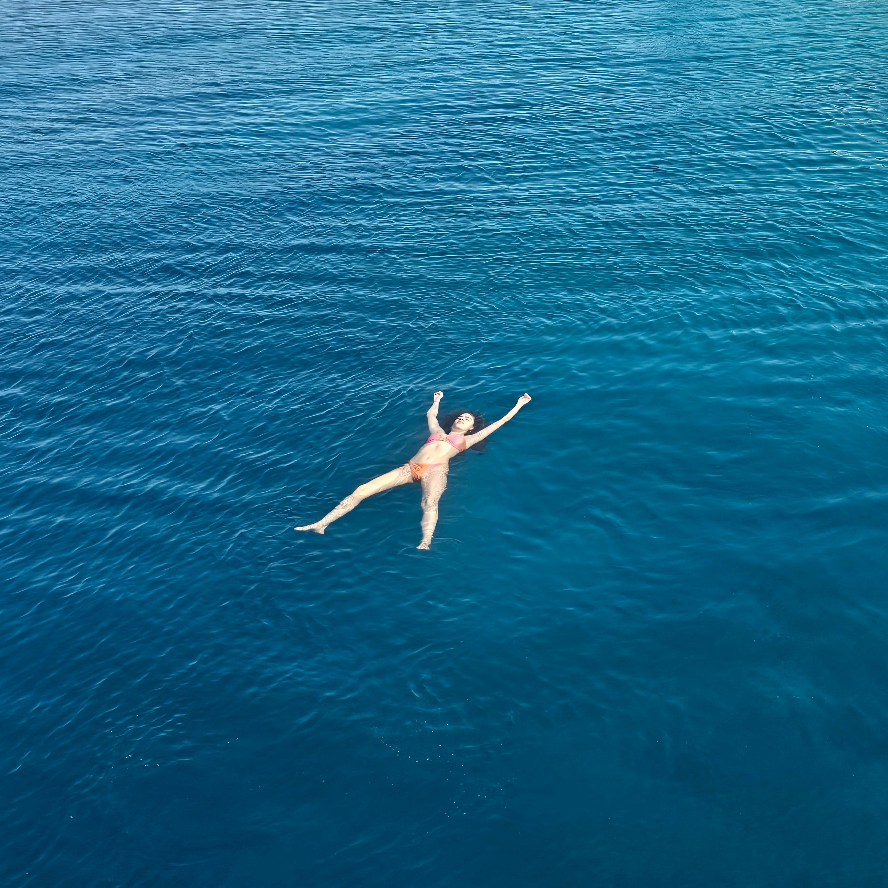 Aerial View of a Woman Floating on the Sea Surface · Free Stock Photo
