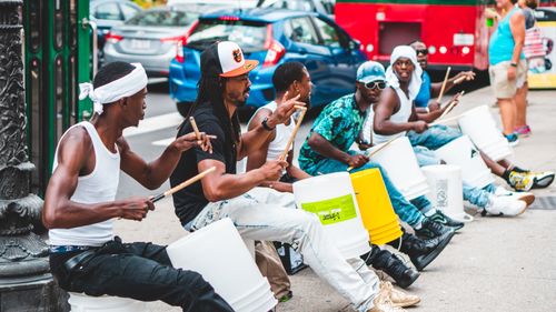 Free Energetic street performers drumming on buckets in downtown Chicago, lively urban scene. Stock Photo
