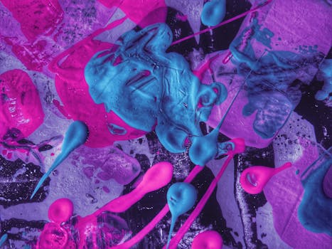 动态抽象艺术中，粉红色和蓝色丙烯酸涂料飞溅，充满活力