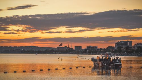 Free A tranquil sunset scene over the water with a boat in Istanbul, Turkey, capturing the city's skyline and warm hues. Stock Photo