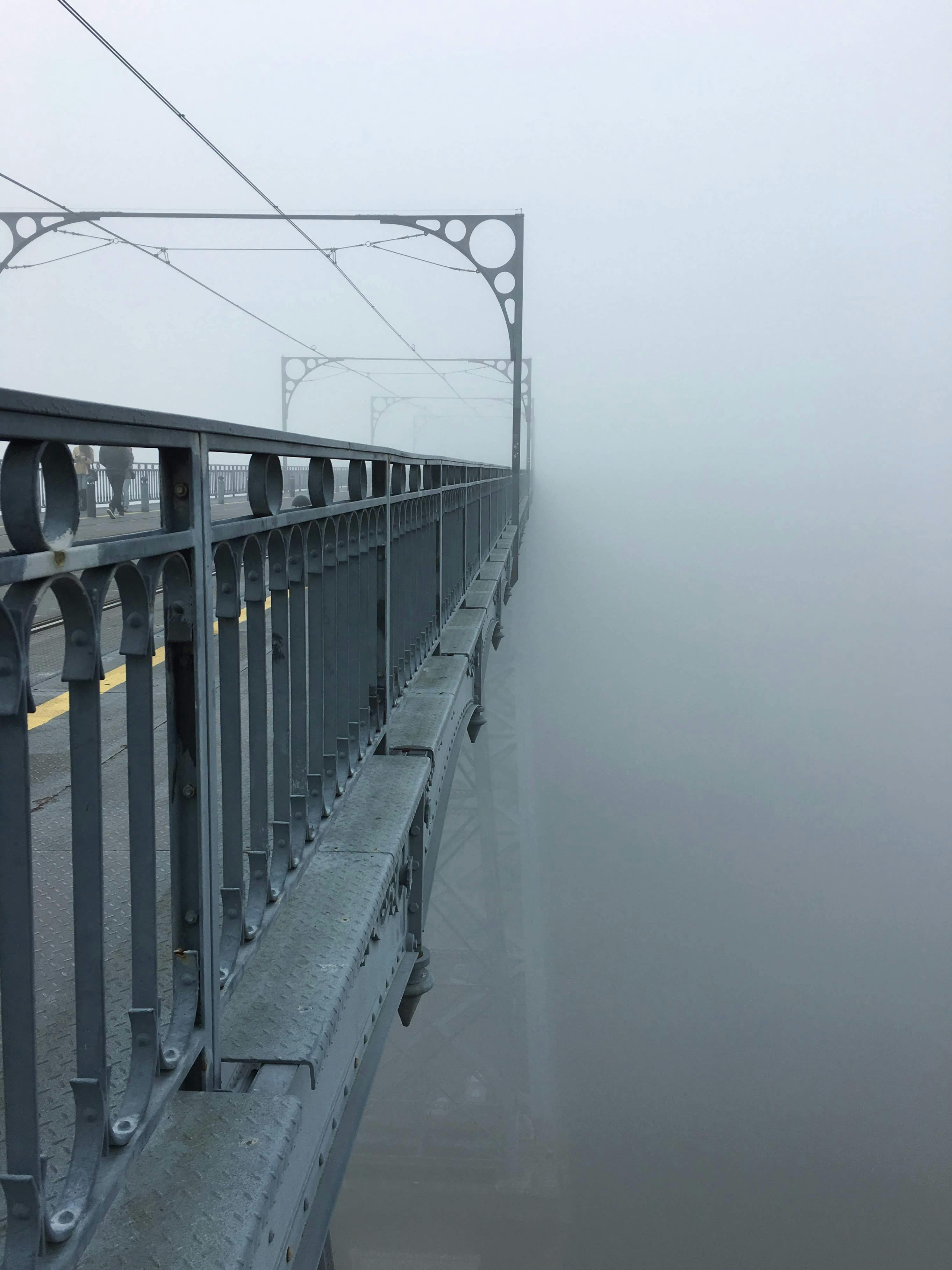 a bridge with metal rails and fog on it