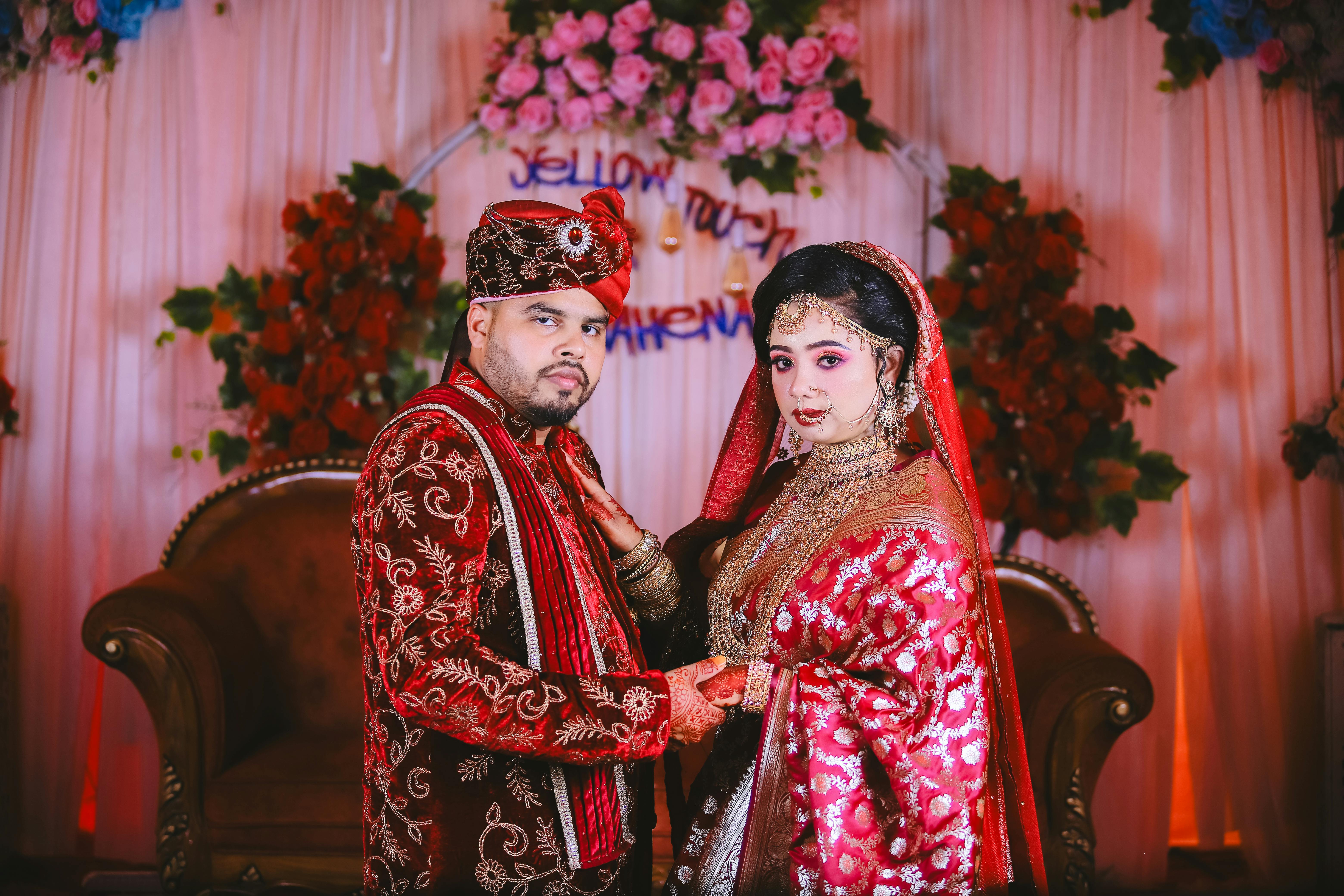 a couple in traditional attire posing for a photo