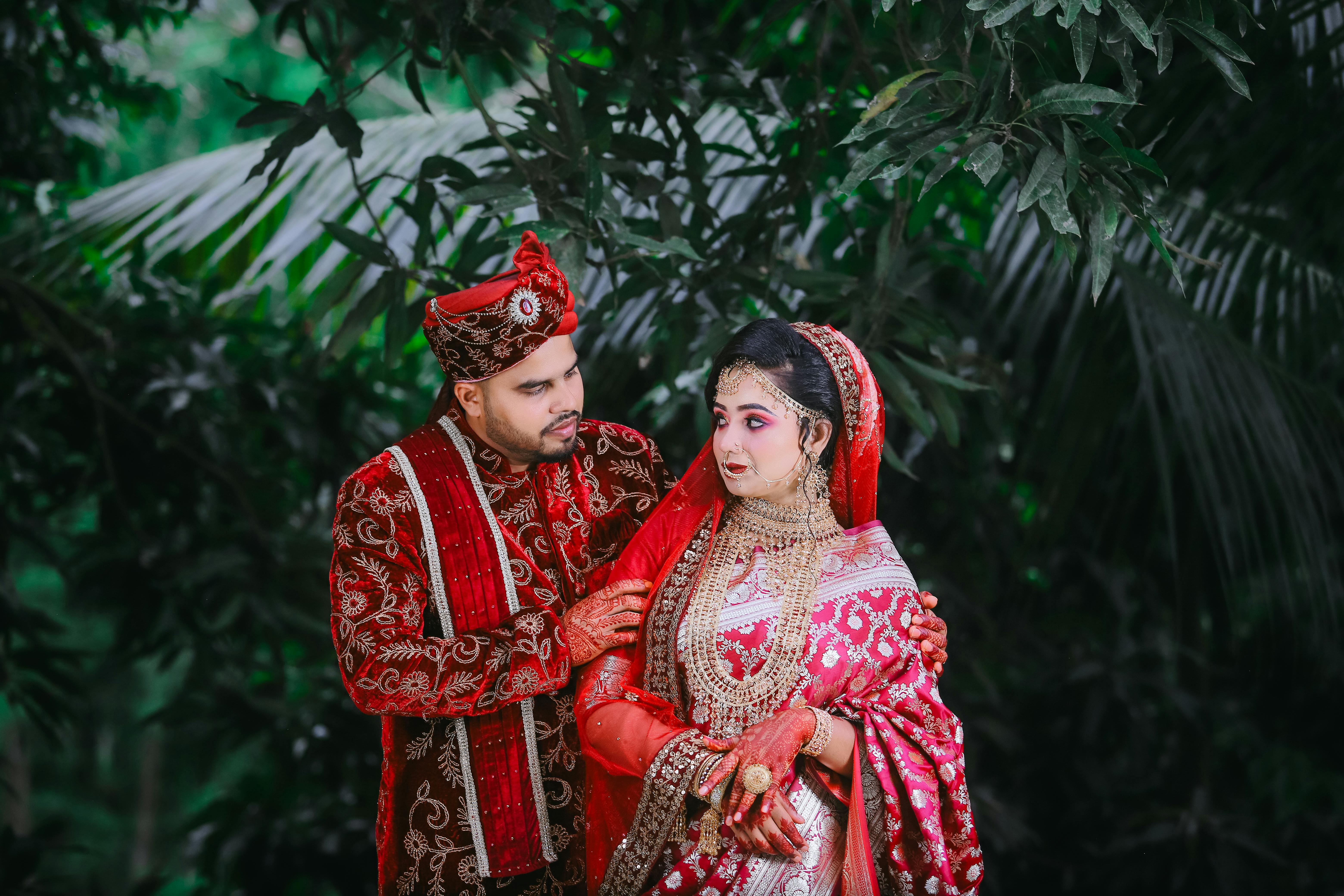 a couple in traditional indian attire pose for a photo