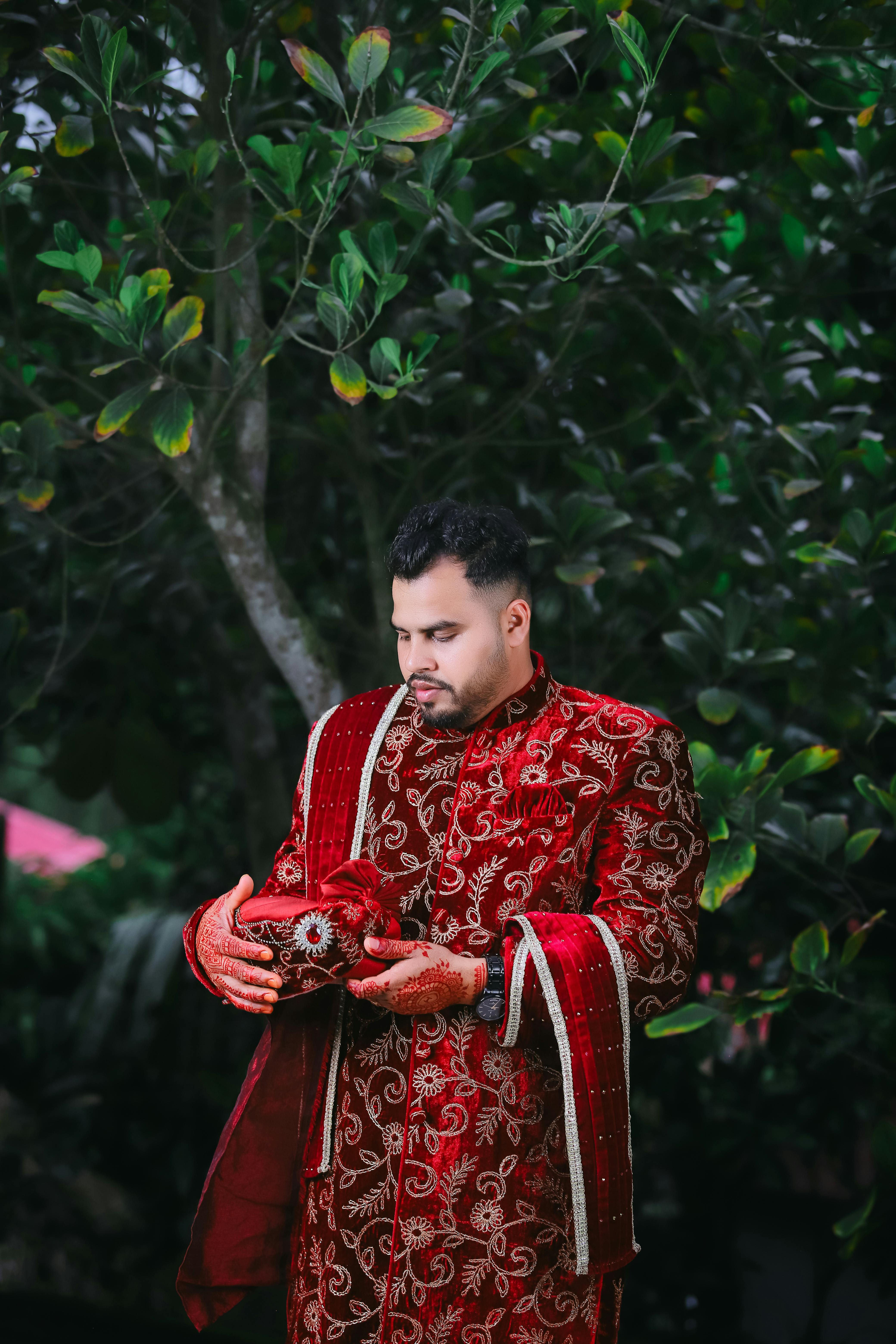 a man in a red and gold outfit holding a bird