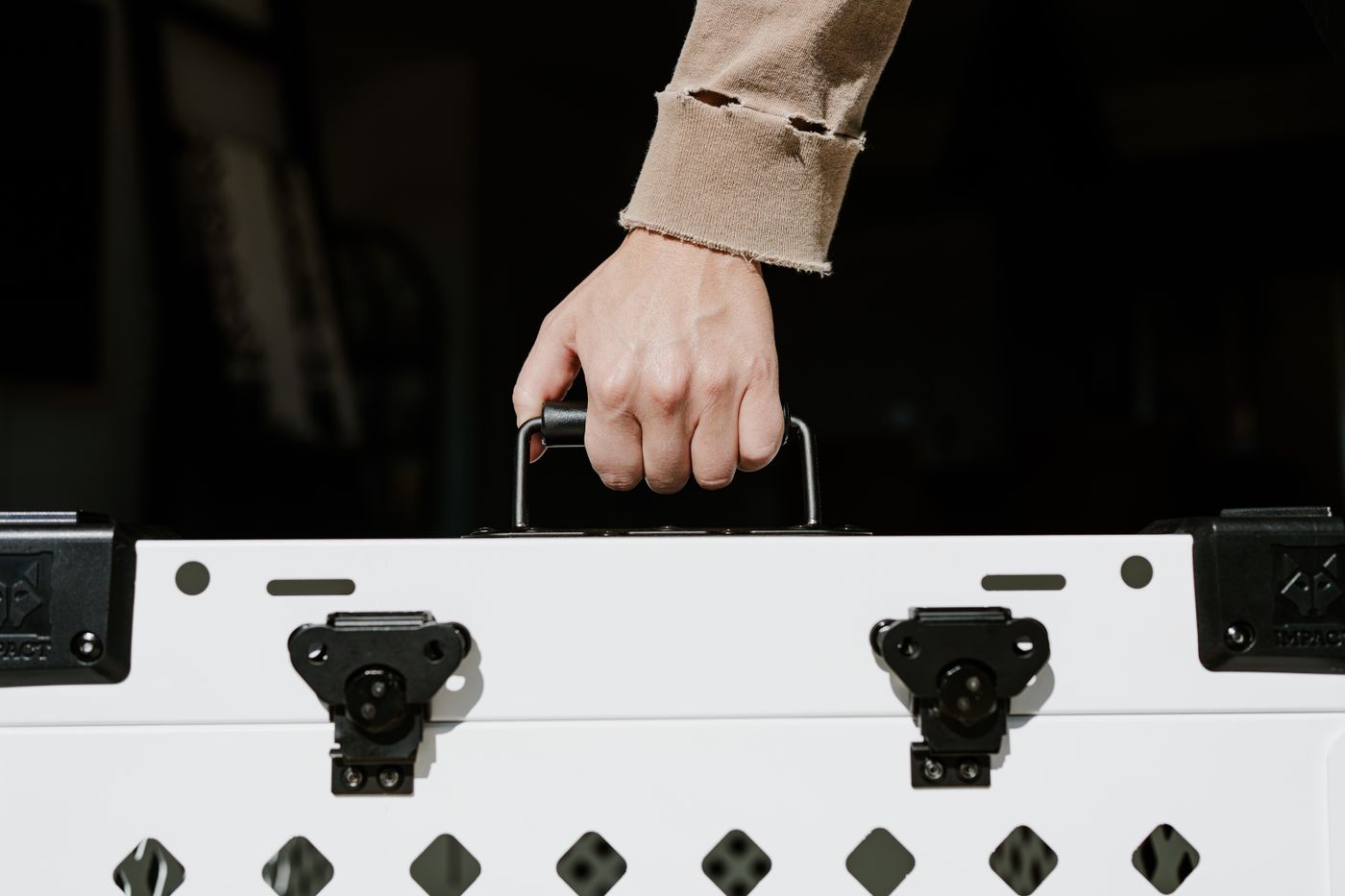 Durable white pet travel crate being handled indoors