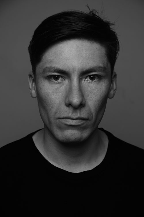 Free Moody black and white portrait of an adult man with serious expression, studio setting. Stock Photo