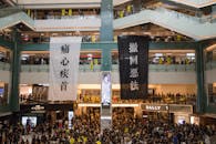 Shopping centre with hanging protestant banners crowded with people on meeting