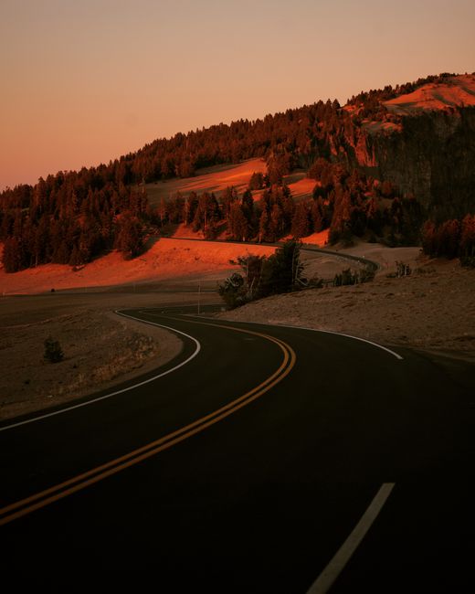 Capture the serene beauty of a winding mountain road in Victorville, California during sunset.