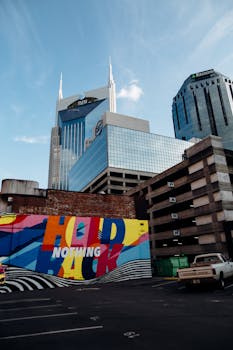 在晴朗的蓝天下，市中心的彩色壁画与摩天大楼和停车场结构交相辉映