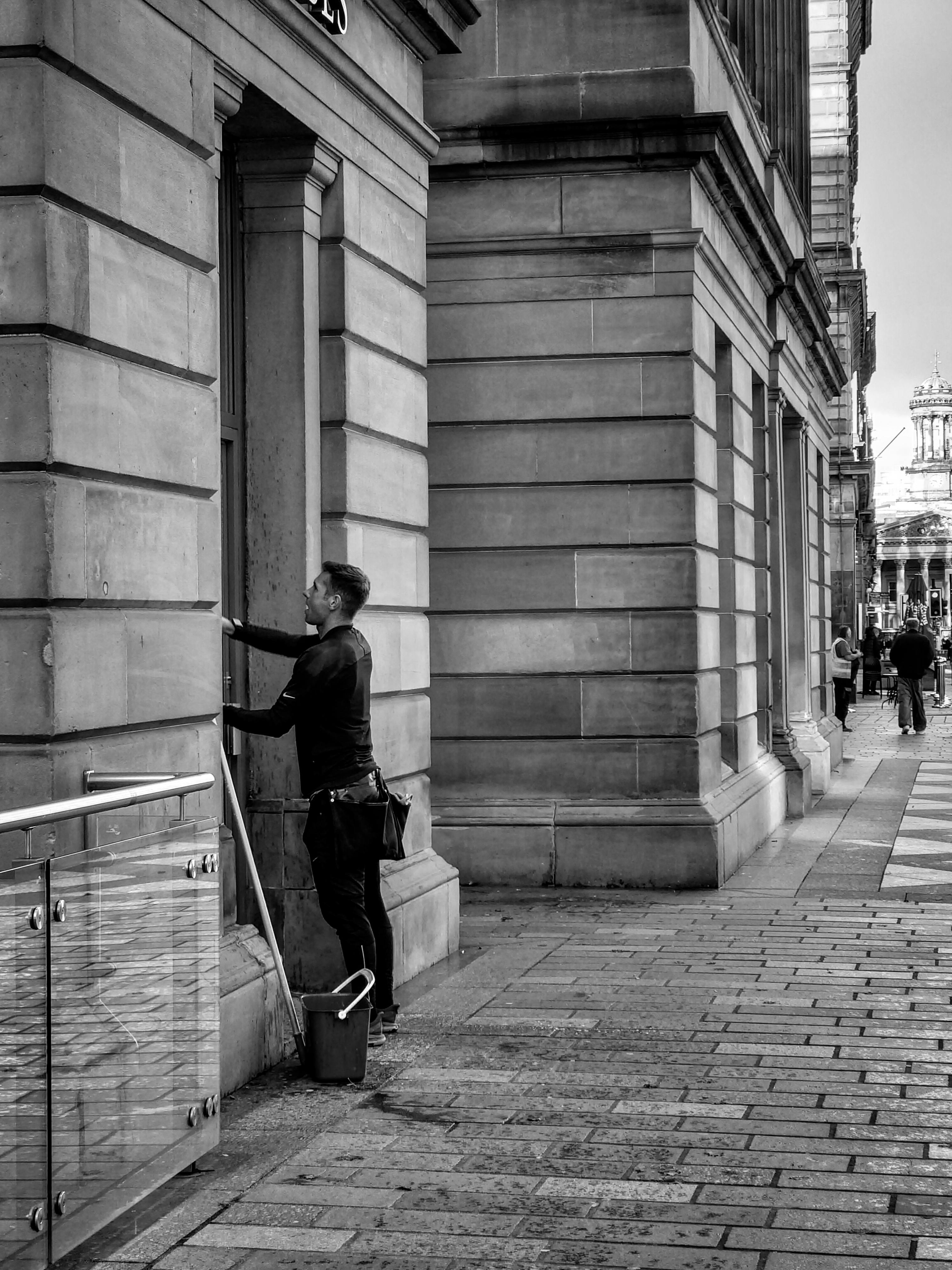 a woman is leaning against a wall in a city