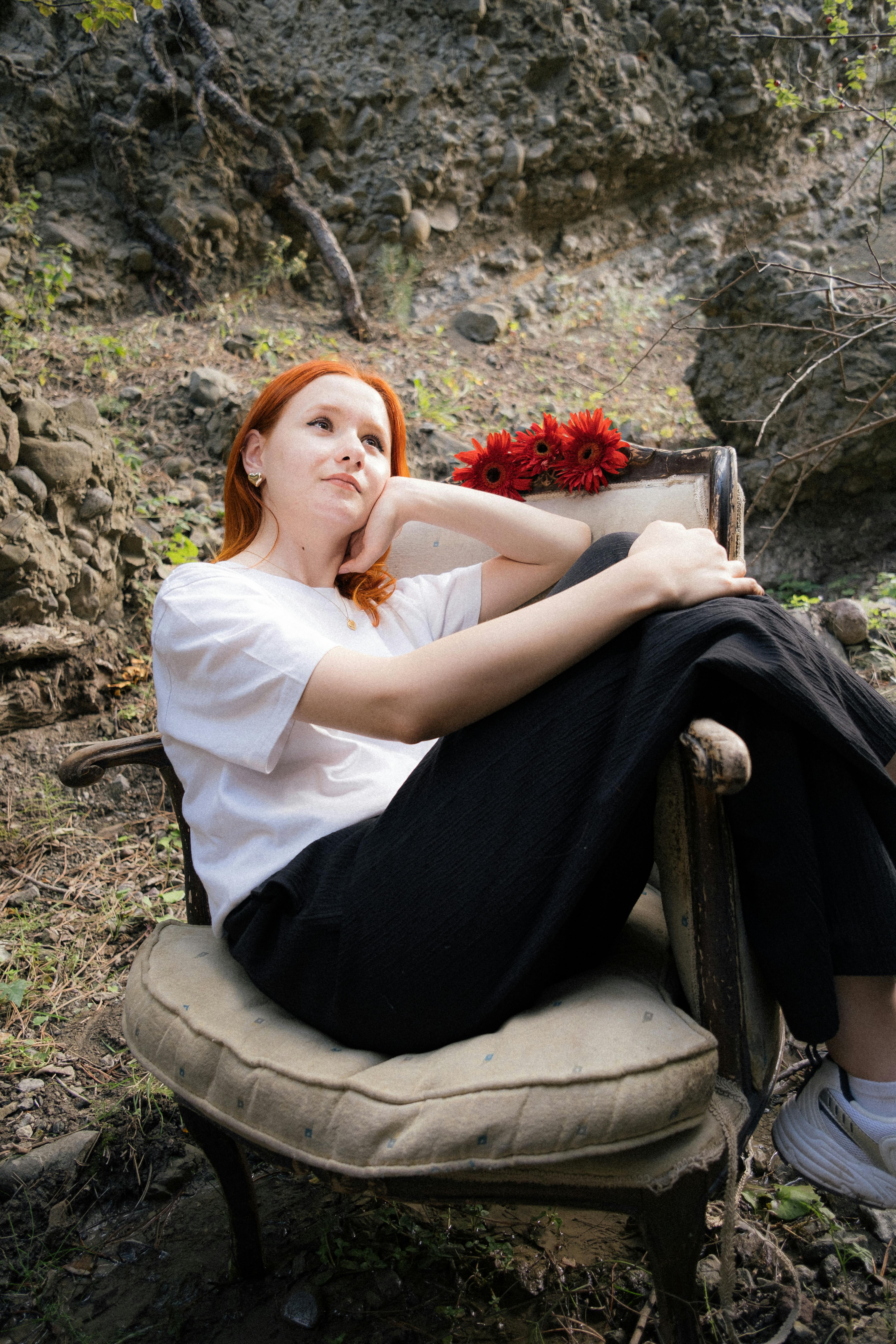 a woman sitting on a chair with red hair