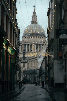 Dramatic street scene with St Paul's Cathedral illuminated by festive lights in London.