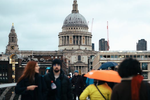 People walking on Millennium Bridge with St. Paul's Cathedral in the background, London.