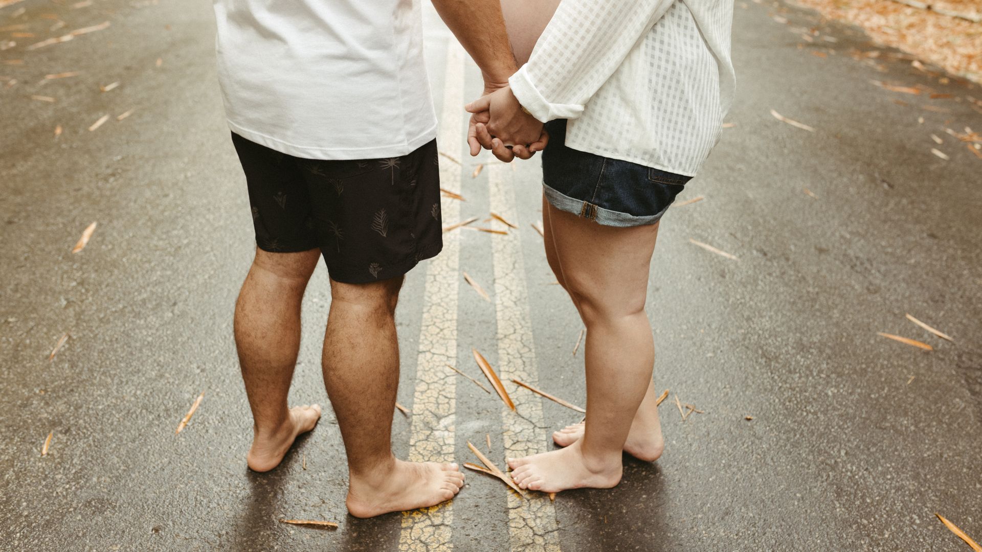 Modafinil Safety While Breastfeeding: A Comprehensive Guide Barefoot expecting couple holding hands on a leaf-strewn road, symbolizing unity and anticipation — modafinil safety while breastfeeding