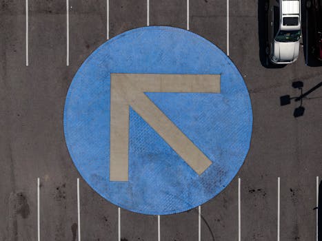 自上而下拍摄的混凝土停车区蓝色箭头交通标志