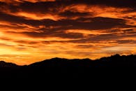 在意大利，山脉的剪影映衬着充满活力、戏剧性的日落天空