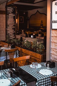 Cozy Istanbul restaurant setting with checkered tablecloths and wooden chairs.