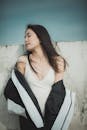 Photo of Woman Wearing White Spaghetti Strap Shirt Leaning on Wall