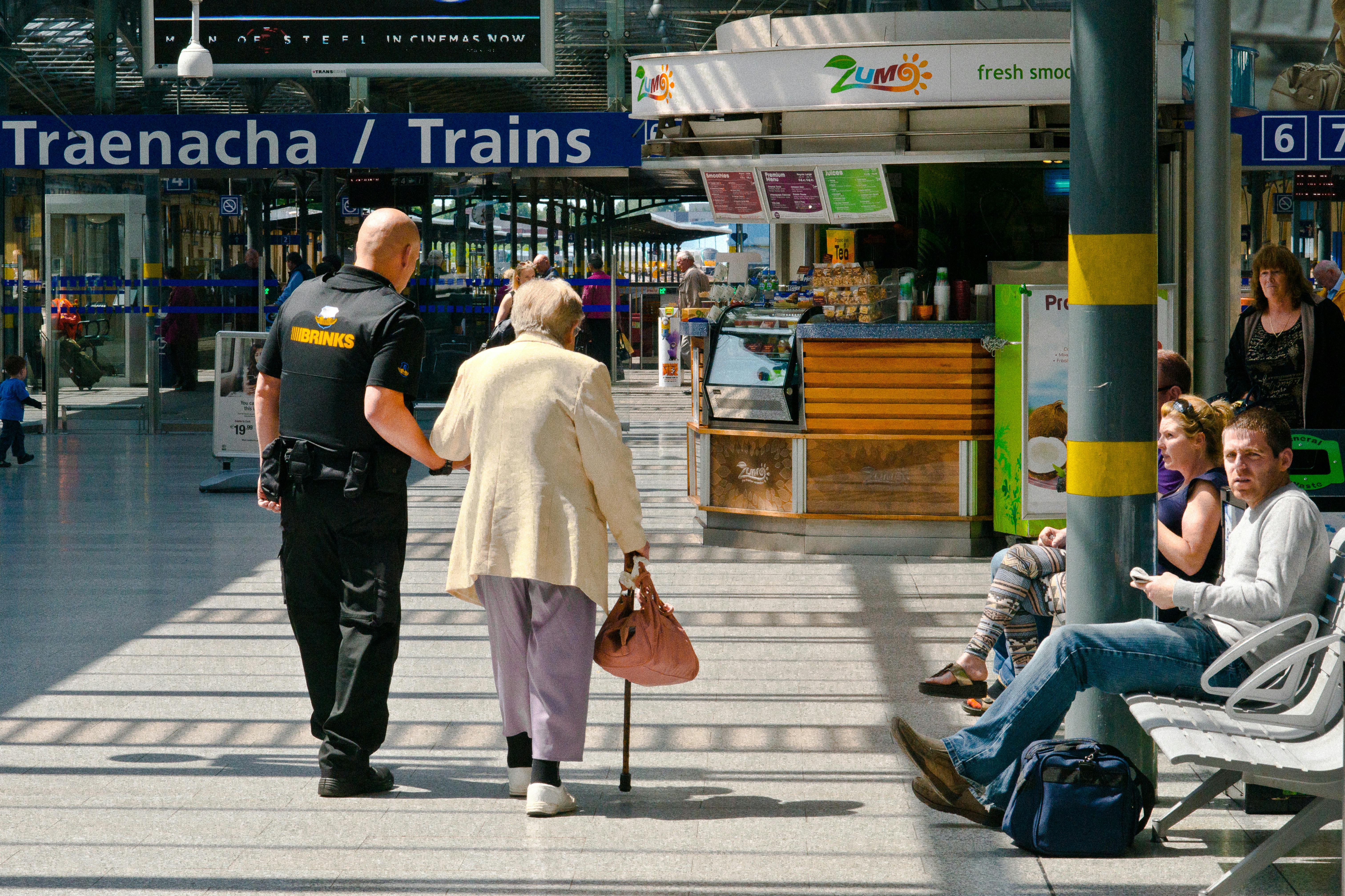 Security Guard Helping Old Lady in Train Station