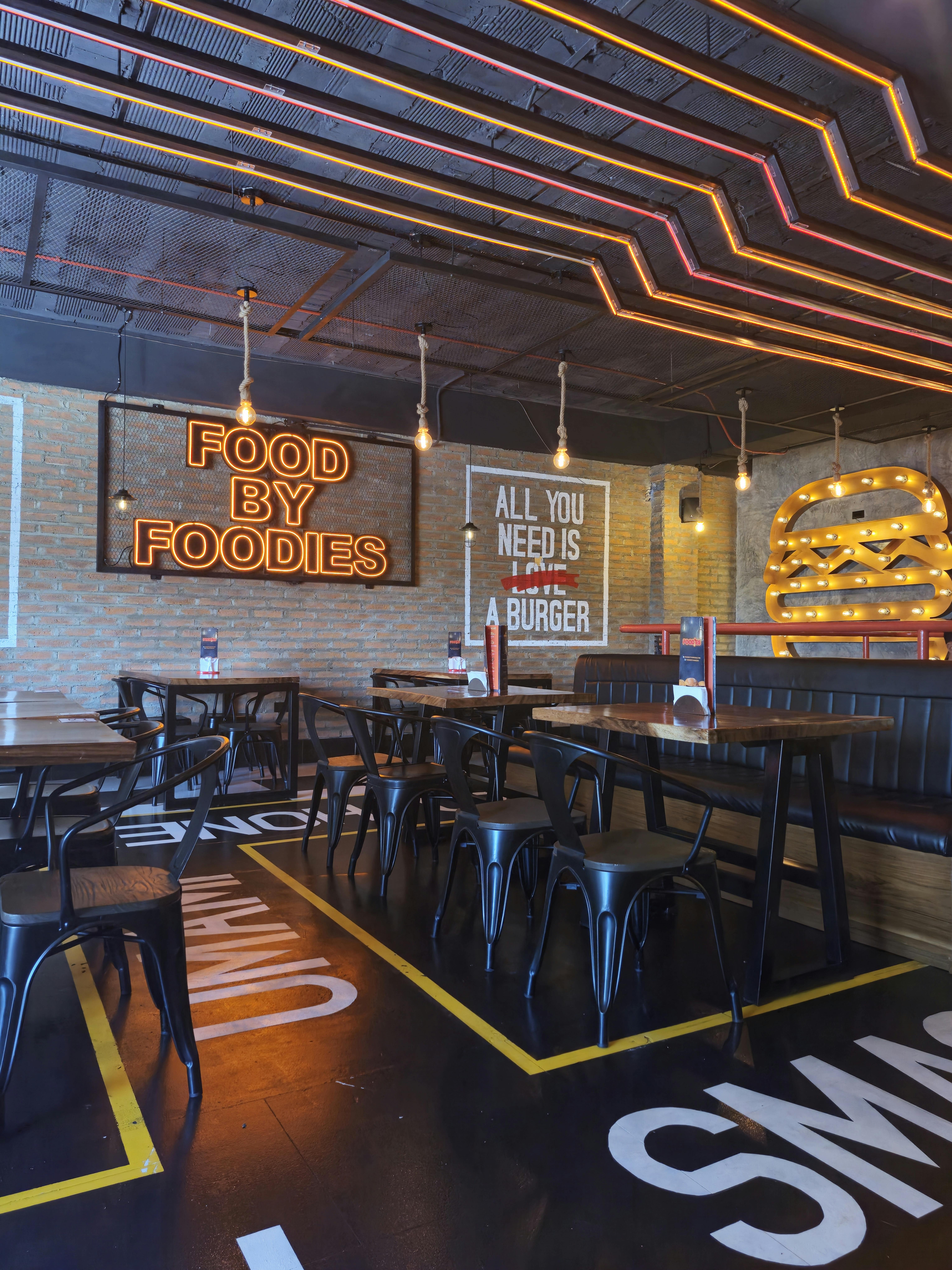 Modern restaurant interior featuring neon signage and industrial design elements.