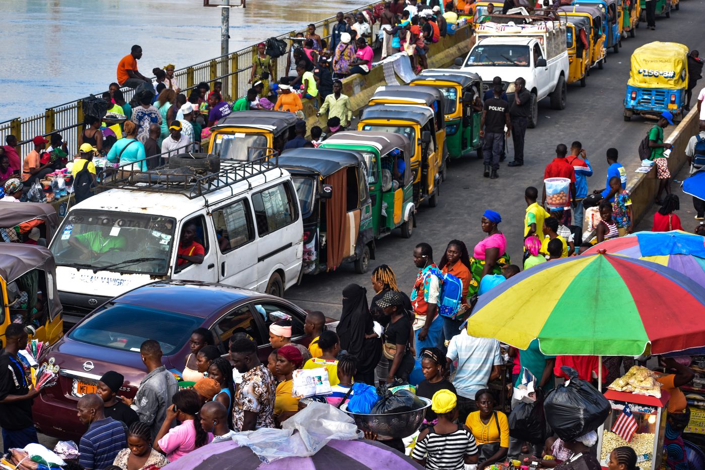 A busy street market with traders, umbrellas and traffic in Monrovia, Liberia