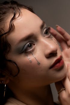 Close-up portrait of a woman with glamorous makeup and glitter details, showcasing artistic style.