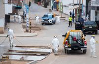 Workers in protective gear sanitize streets in Chorrillos, Lima, to curb COVID-19 spread.