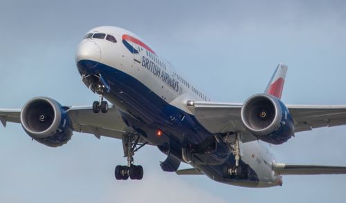 Free Close-up of a British Airways airplane in flight with a blue sky background. Stock Photo