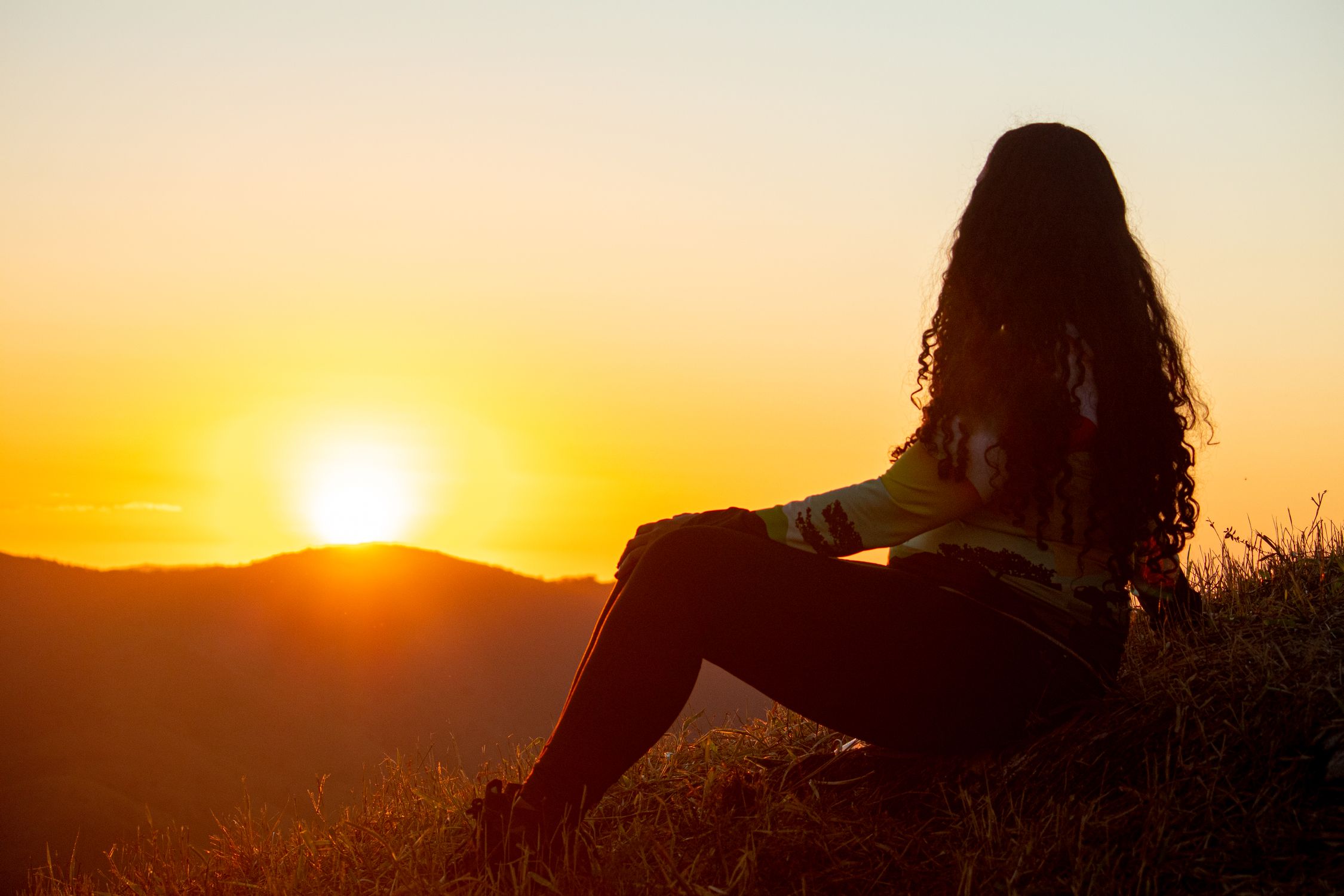Woman Sitting on Field in Countryside at Sunset · Free Stock Photo
