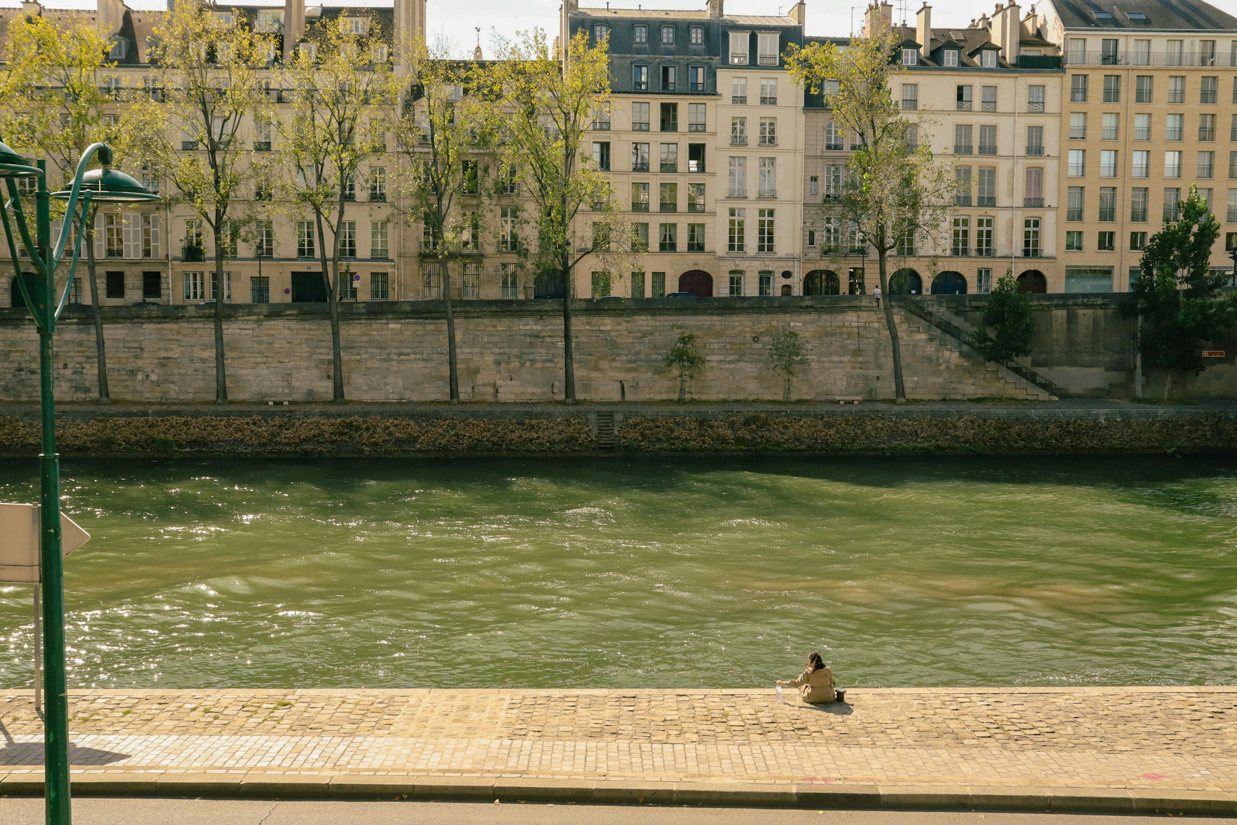 A serene moment by the Seine River with historic Parisian buildings in the background.