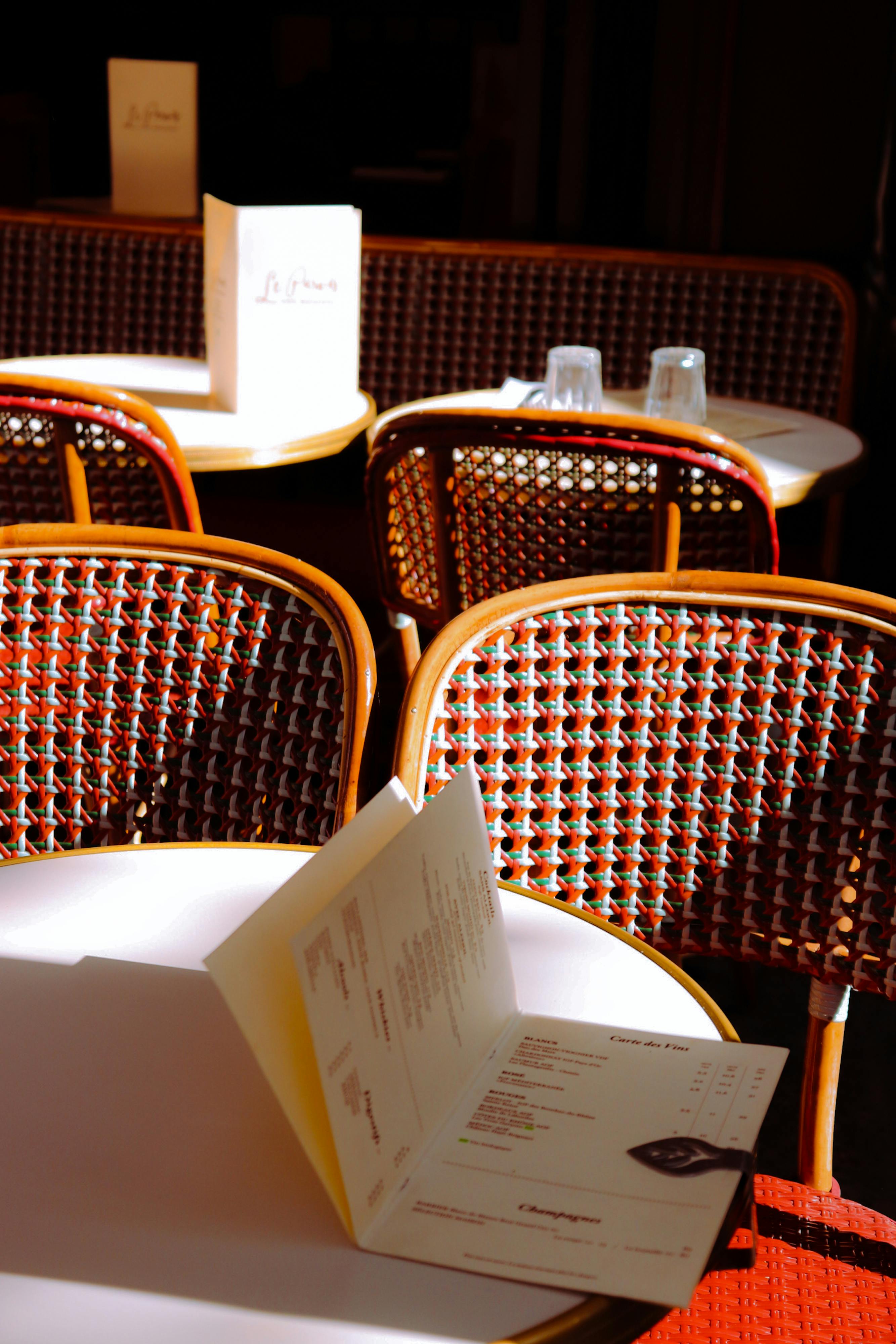 Sunlit empty tables at a Parisian café, showcasing classic French charm.