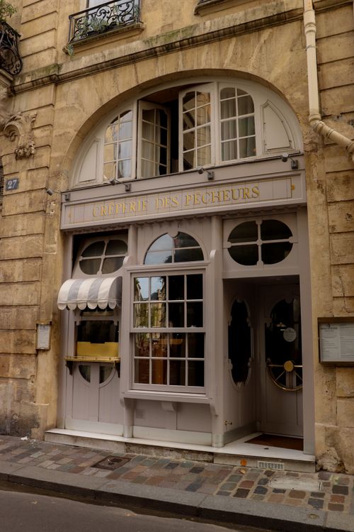 Free Elegant Parisian cafe facade with vintage charm, located in a historic street. Stock Photo