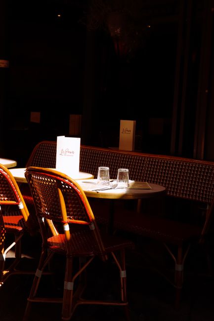 Charming Parisian cafe with empty chairs and table set in warm afternoon light, evoking Paris ambience.