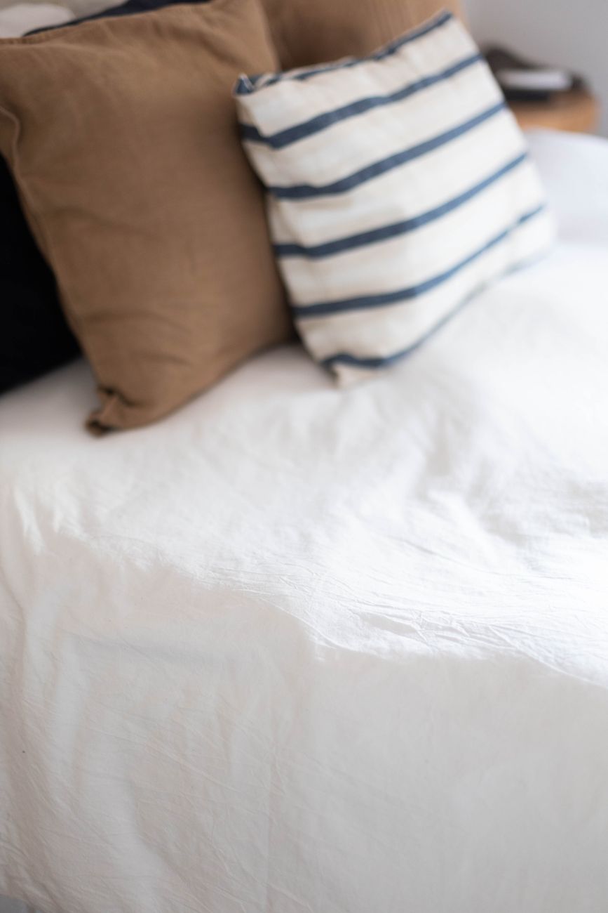 A close-up of a cozy bed with brown and striped cushions, perfect for a comfortable and inviting bedroom interior.
