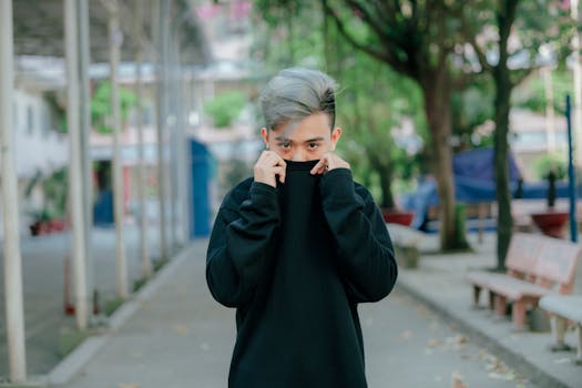 一个银发的年轻人在户外休闲环境中穿着黑色毛衣的肖像