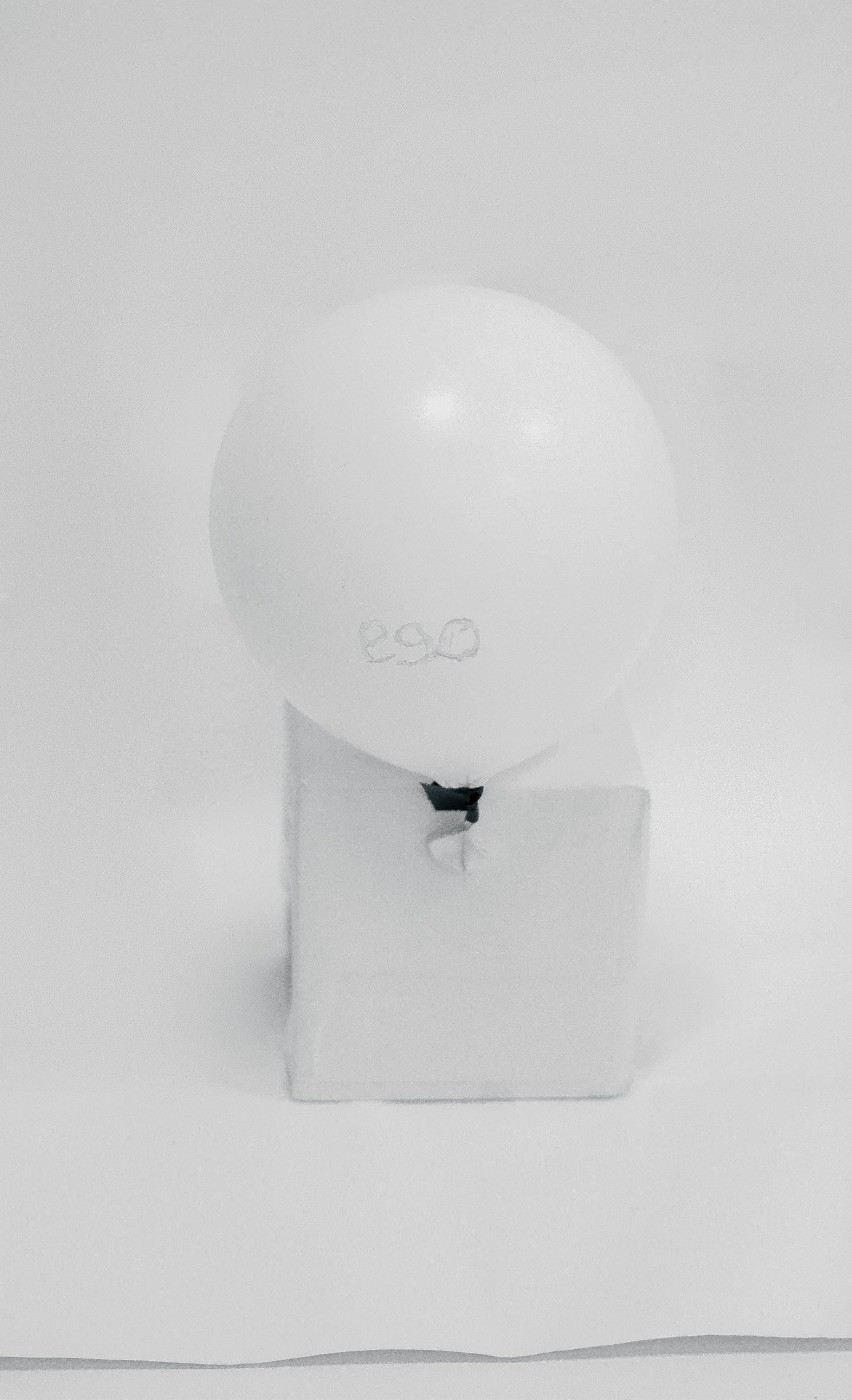 A single white balloon with 'ego' text floating against a clean, minimalist background.