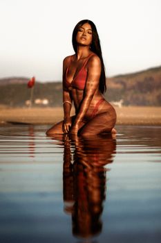 Model in a bikini posing at a beach in Niterói, Rio de Janeiro, during sunset.