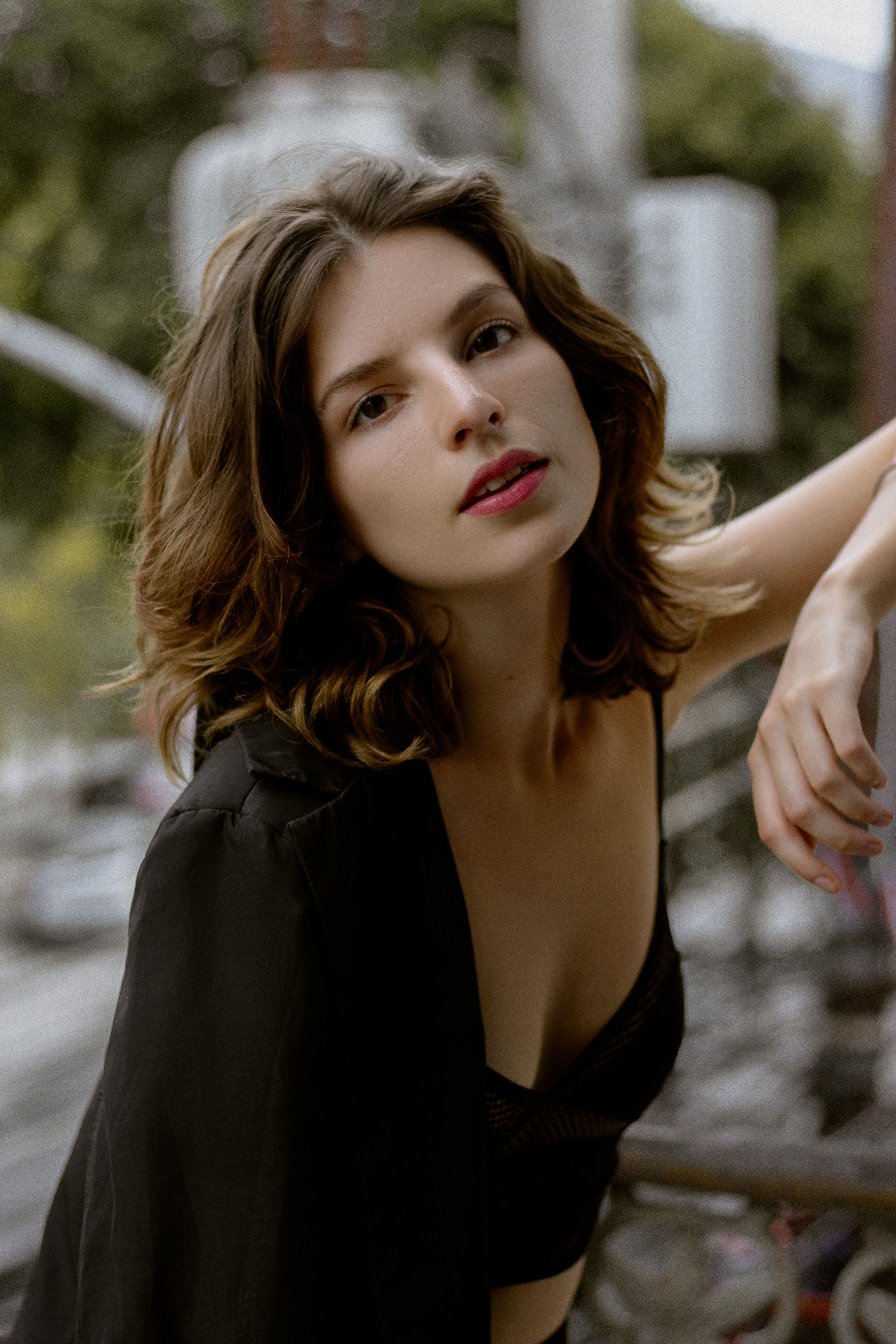 Fashionable woman with brown hair posing outdoors in Rio. A blend of elegance and natural beauty.