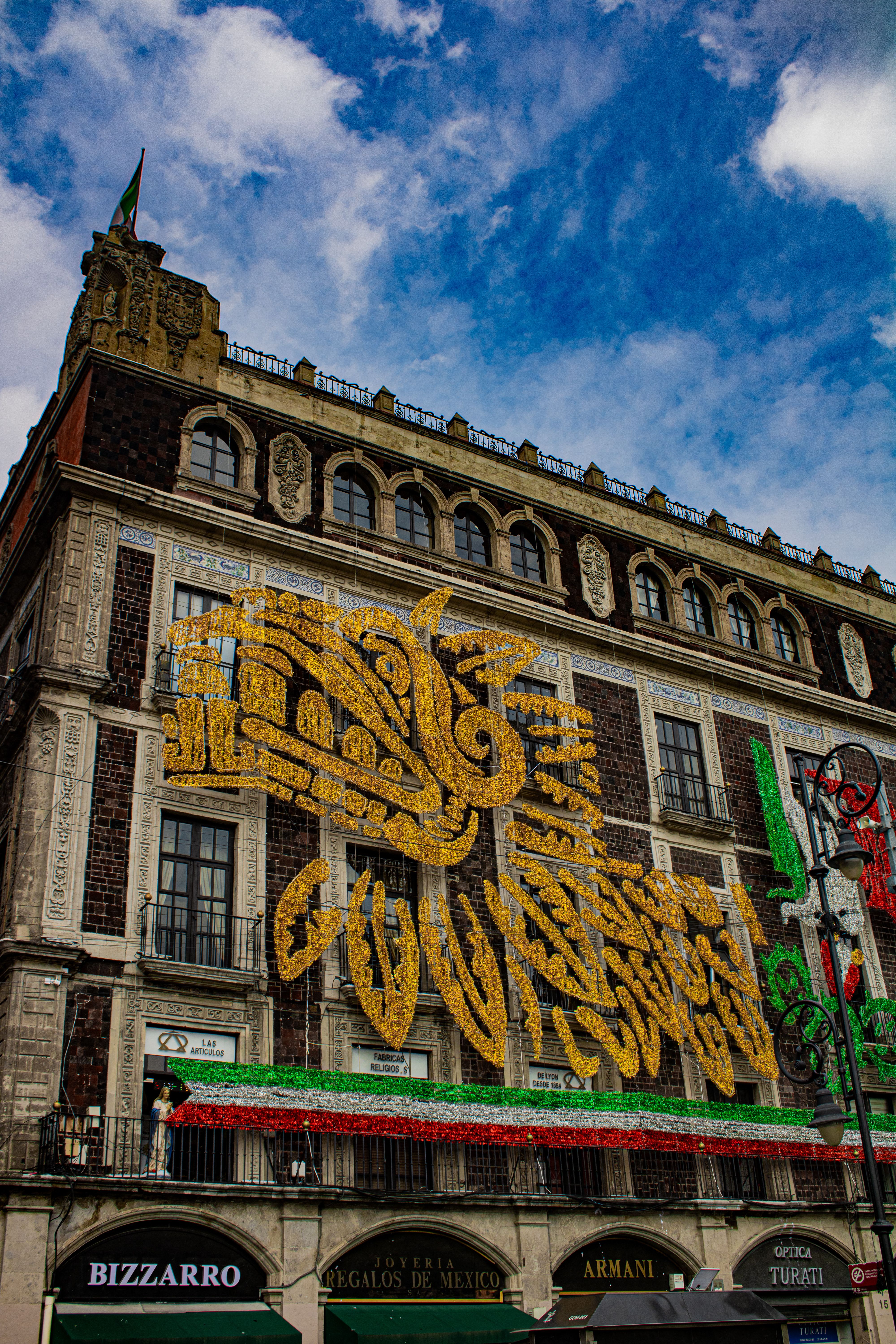 Colorful dragon mural on a historic building facade under a vibrant blue sky.